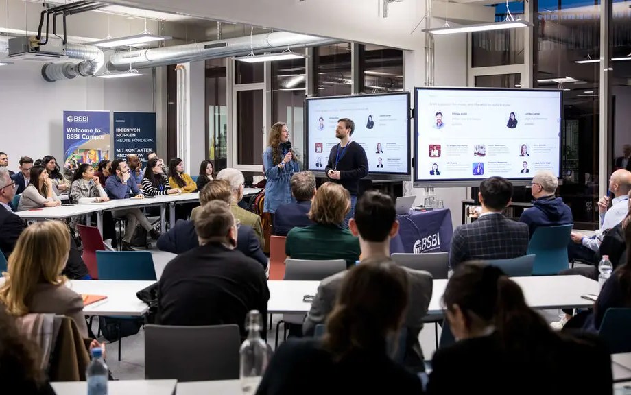 hoto of an audience attending a business workshop or presentation at BSBI campus, with two speakers presenting in front of large screens